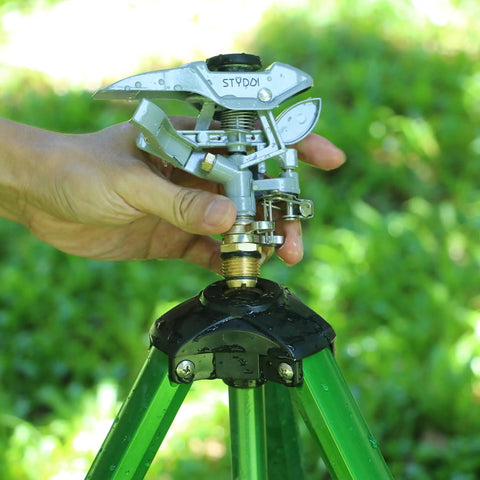 Heavy Duty Metal Impulse Sprinkler Head With Half Inch NPT Thread being installed on a tripod in a garden setting