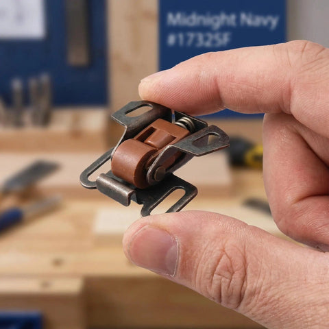 Close-up of 10 Pack Heavy Duty Roller Catch Cabinet Door Latch Set With Spring Loaded Mechanism in hand, ancient red