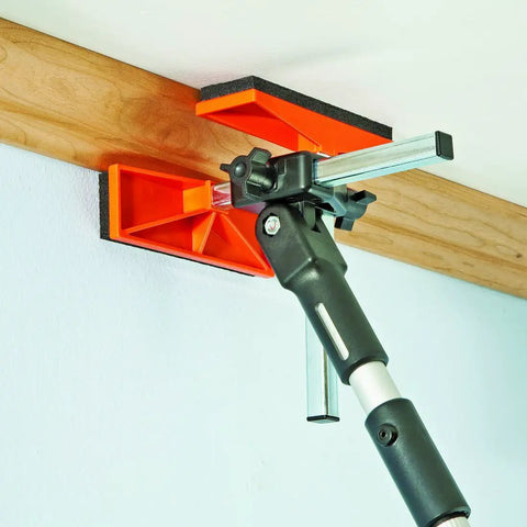 Adjustable Third Hand Crown Molding Support Pole for Ceiling Trim Installation in use, securing molding to ceiling.