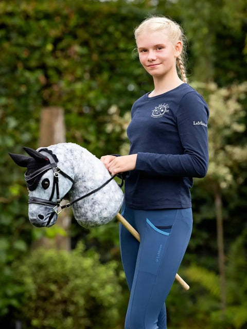 Person holding Hobby Horse Toy Competition Bridle in Black with Padded Leather Browband and Noseband in a garden setting
