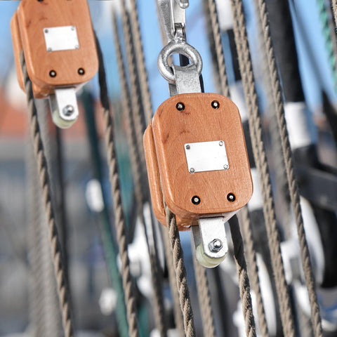 Close-up of Two Pack Four Inch Wood Manila Rope Pulley Block With Hook Single Wheel Cable Pulley in marine setting