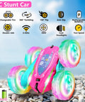 Pink Remote Control Car For Girls That Flips 360 Degrees on rocky surface, double-sided with bright wheel lights, rechargeable batteries included.