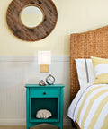 Gold Mid Century Wall Sconces Set Of 2 With White Linen Shade next to bed with rattan headboard in cozy hotel vibe setting