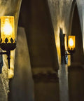 Outdoor No Brainer Dusk To Dawn LED Bulb illuminating a row of wall sconces in a dimly lit hallway