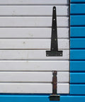 Heavy Duty 12 Inch Black Iron T Shape Slotted Bearing Door Hinge With Easy Adjustable Fit for heavy doors on white and blue panel door.