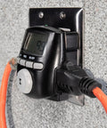 Digital Astronomic Landscape Timer With Precision Lighting Control plugged into wall outlet, showing display and connected cords.