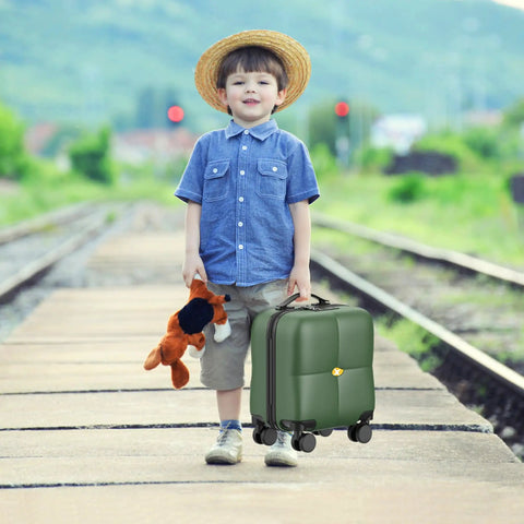 Young boy with toy and 14 Inch Underseat Carry On Luggage With Wheels, Dark Green on train tracks.
