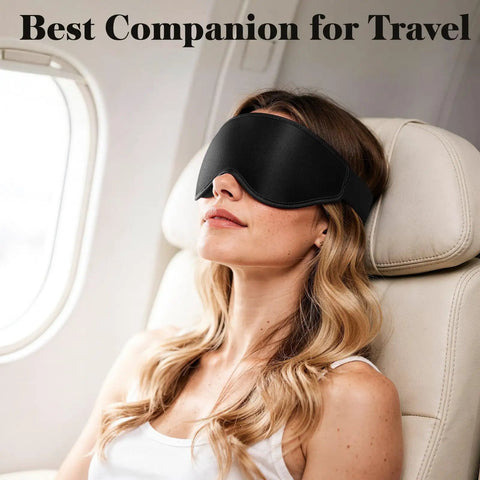 Woman using 3D Eye Mask For Sleep And Travel For Men And Women, 100 Percent Pressure Free Contoured Eye Pockets on airplane, adjustable strap, black.