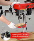 8 Inch Benchtop Drill Press With Laser Guide And Led Light being used for wood drilling on a workbench with gloves on.