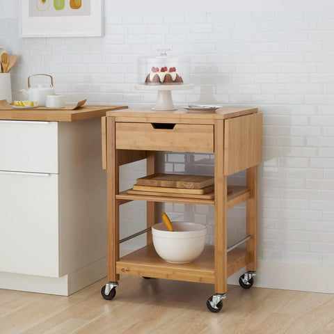 Premium Bamboo Extendable Rolling Kitchen Cart With Collapsible Drop Leaves And Deep Storage Drawer beside kitchen counter.