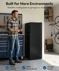 Man standing next to Badass 7 Cubic Foot Upright Freezer With Five Adjustable Shelves, ideal for garages and compact spaces.