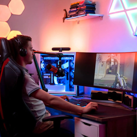 Gamer using an adjustable 360 degree microphone boom arm with stainless steel desk mount for precise mic placement while gaming.