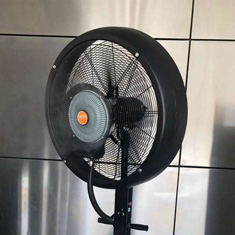 No Sweat Commercial Misting Fan Delivers Beast Mode High Velocity Airflow For Restaurants And Warehouses Featuring Rock Solid Metal Housing And Quick Adjustable Tilt Swivel In Blue, close-up view of fan with mist.