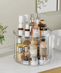 Front view of clear acrylic two-tier LazySpin Lazy Susan on bathroom counter, holding assorted cosmetic bottles