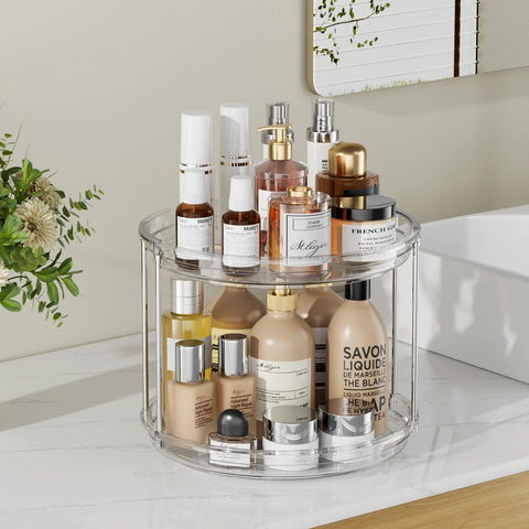 Front view of clear acrylic two-tier LazySpin Lazy Susan on bathroom counter, holding assorted cosmetic bottles