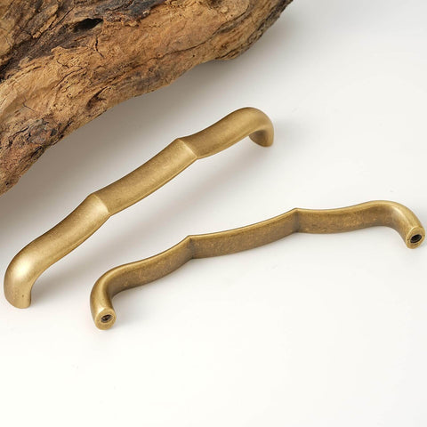 Solid Brass Cabinet Pulls 5 Pack, 5 Inch Hole center drawer handles in antique brass next to wood surface, modern classic design.