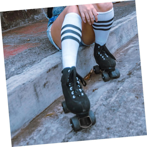 Skater resting wearing quad roller skates with Adjustable Elastic Brake Block For Quad Roller Skates And Ice Skates Rubber Brake Stopper Kit