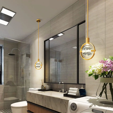 Dope Modern Crystal Pendant Light In Gold Brushed Brass Finish with 4.33 Inch K9 Crystal, installed in a bathroom setting.