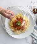 Hand lifting 10 Inch Plate Cover Dome Shield For Mess Free Cooking And Keeping Leftovers Hot on pasta with sauce, 3.1 inch high