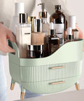 Slick Green Makeup Organizer With Two Deep Drawers And Sturdy Carry Handle, Large Skincare Storage Box For Vanity Tops, filled with skincare bottles.