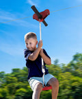 Child using Backyard Zip Line Kit For Kids And Adults, 120 Foot Outdoor Zipline with Swing Seat and Spring Brake.