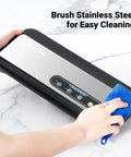 Powerful 90KPa 8-in-1 Food Vacuum Sealer brushed stainless steel surface being cleaned with blue cloth