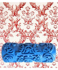 Top Tier 5 Inch Pattern Texture Paint Roller With Grippy Embossed Handle For Swift Diy Wall Murals And Slick Latex Coating That Covers Imperfections Like A Badass Champion against a red patterned wall.