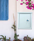 Tough As Nails Outdoor Waterproof Junction Box For Low Voltage Circuits installed on outdoor wall next to blue window