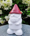 Front view of a gnome table torch with a red hat, part of the Two Pack Gnome Table Torches For Outdoor Patio And Backyard.