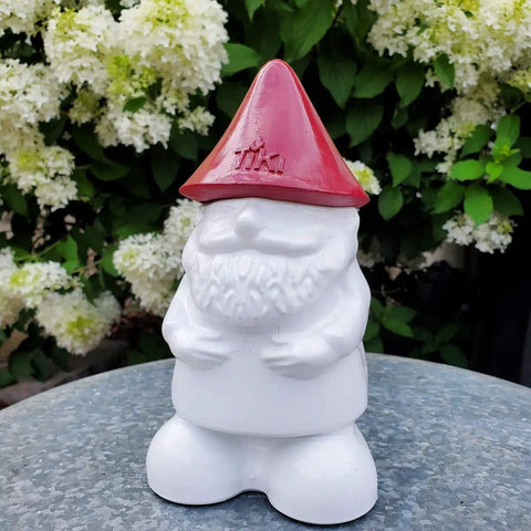 Front view of a gnome table torch with a red hat, part of the Two Pack Gnome Table Torches For Outdoor Patio And Backyard.