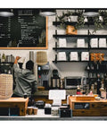 Hella Durable Unbleached Brown Biodegradable Coffee Filters Fit 10 To 15 Cup Baskets in a cafe setup with coffee equipment.