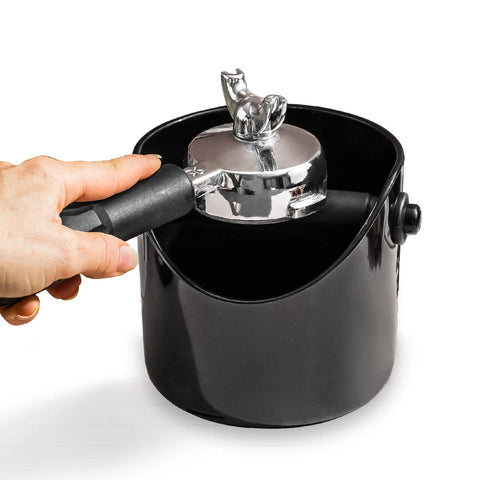 Grindenstein Espresso Knock Box Sturdy and Compact Black Coffee Grounds Container in use with hand knocking portafilter.