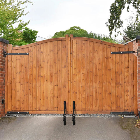 Wooden gate with Spring Loaded Gate Wheel With 360 Degree Swivel For Heavy Gates Outdoor Gate Caster Kit installed on driveway