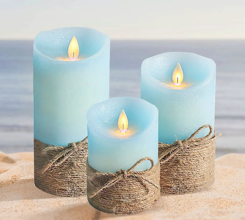 Ocean Blue Flameless LED Pillar Candles Set Of 3 With Remote And Timer, on a sandy beach backdrop.