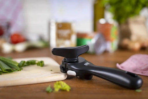 No-Touch Can Opener With Ring-Pull Tool And Auto Safety LidLifter Smooth-Edge Side-Cut Design For Safe Lid Removal Easy-Turn Handle Swiss Engineered Red, black can opener on cutting board