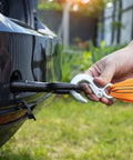 Close-up of PATIKIL 1.7-inch zinc-plated hook safety latch attached to a trailer hitch receiver with orange strap.