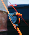 Real Deal Heavy Duty Retractable Ratchet Tie Down Straps Orange One Inch By Sixteen Feet Two Pack self locking buckle and strap close up.