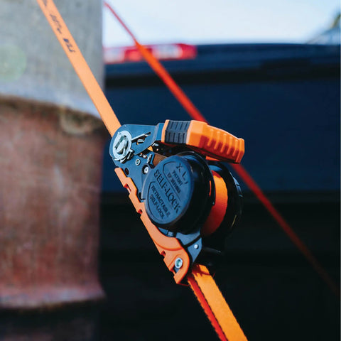 Real Deal Heavy Duty Retractable Ratchet Tie Down Straps Orange One Inch By Sixteen Feet Two Pack self locking buckle and strap close up.