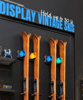 Heavy Duty Wall Mounted Ski And Snowboard Rack For Garage Keeps Gear Crash Proof Featuring Soft Rubber Holders That Lock Boards Rock Solid And Super Sweet Storage Setup Blue 4 Pack displaying four vintage skis mounted on wall.