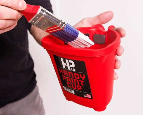 Person holding Grab And Go 16 Oz Paint Cup With Magnetic Brush Holder For Trim Work And Touch Ups Mess Free Quick Cleanup