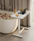 Total Game Changer Over Bed Table With Smooth Rolling Casters And No Sweat Pneumatic Height Adjustment Super Spacious Work Surface beside bathtub.