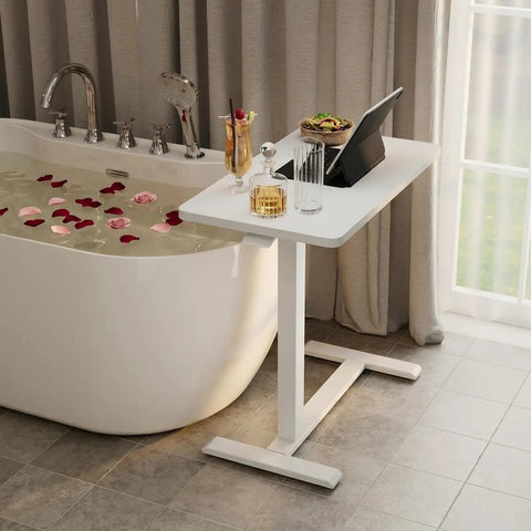 Total Game Changer Over Bed Table With Smooth Rolling Casters And No Sweat Pneumatic Height Adjustment Super Spacious Work Surface beside bathtub.