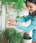 Woman using Diatomaceous Earth Bulb Duster With Long Copper Tube Garden Sprayer Applicator For Organic Gardening Pest Control