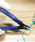 Close-up of 10 Pack Flush Wire Cutters Pliers Set With Diagonal Side Cutting Jaws For Jewelry Making And Crafts Ultra Sharp High Carbon Steel Blades Five Inch Palm Size For Clean Precise Cuts trimming wire with blue handles.