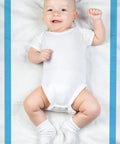 Smiling baby lying on Super Absorbent Disposable Underpads And Incontinence Bed Pads 23 X 36 Inch with blue border.