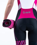 Person holding a rolled Large Neoprene Triathlon Transition Mat Teal Blue For Crowded Transitions wetsuit changing pad in pink triathlon suit.