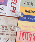 Legit Durable Push Pins 600 Count Standard Thumb Tacks With Kickass Steel Points And Clear Rounded Tops attached to colorful papers on cork board