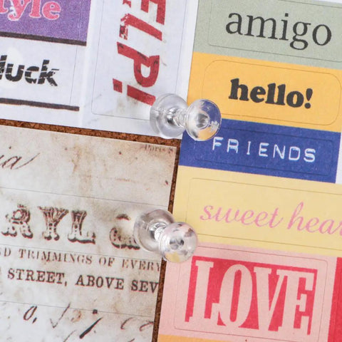 Legit Durable Push Pins 600 Count Standard Thumb Tacks With Kickass Steel Points And Clear Rounded Tops attached to colorful papers on cork board