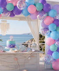 Sea Theme Confetti Balloons Party Kit 50Pcs 12 Inch Iridescent Pink Purple Blue Teal For Princess Birthday Bash Decor Ocean Theme Party Supplies Set With Colorful Confetti Balloons And Ribbon displayed at an oceanfront party setup.