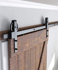 Heavy Duty Sliding Barn Door Hardware Kit in Black with Industrial Wheel Hangers, fits 36 to 40 inch wide panels, installed view.